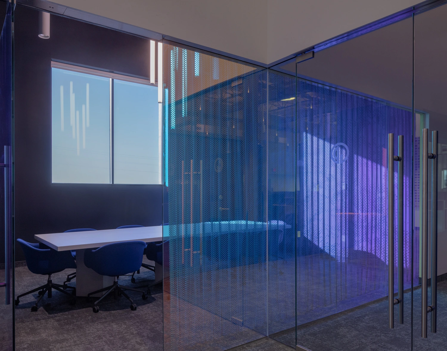 Interior perspective looking through a vibrant, blue-tinted translucent partition wall in a modern office setup.